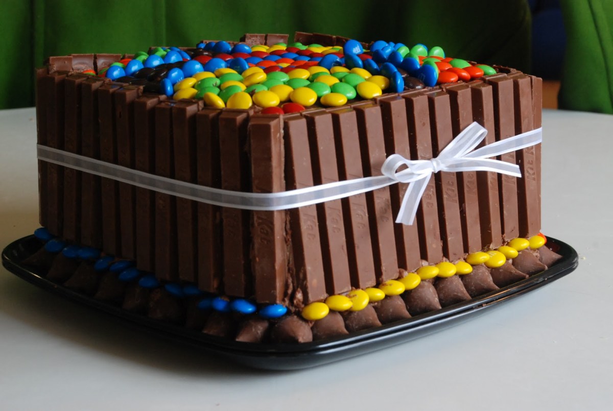 Peaunut butter candy cake decorates with KitKats, M&M's, and Hershey's Kisses.